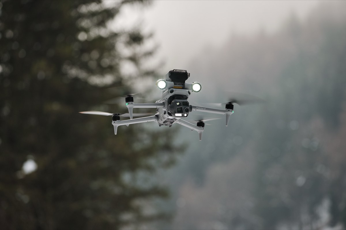 Kameradrohne im Flug vor einem Tiroler Wald